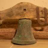 Ai piedi della cattedra troviamo invece la campana della chiesa, datata 1709 e ancora inserita nel suo supporto in legno